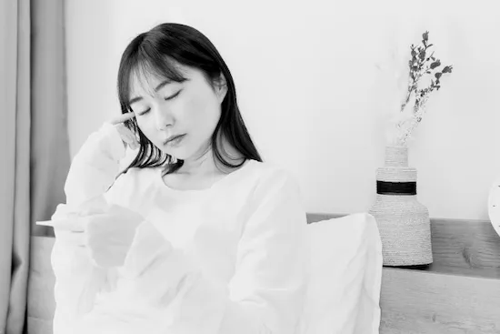 デスクワークで疲れを感じる女性のイメージ